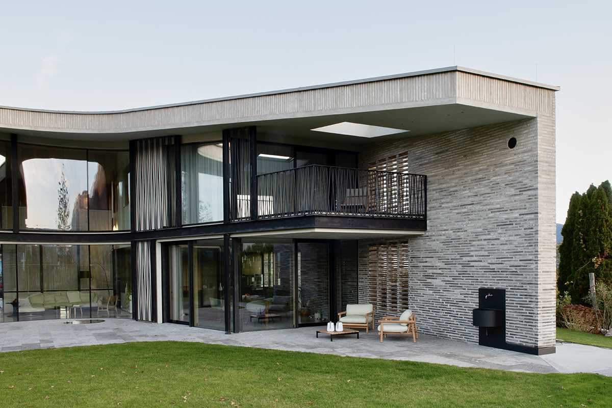 A modern home features handmade elongated bricks ranging from dark to light.