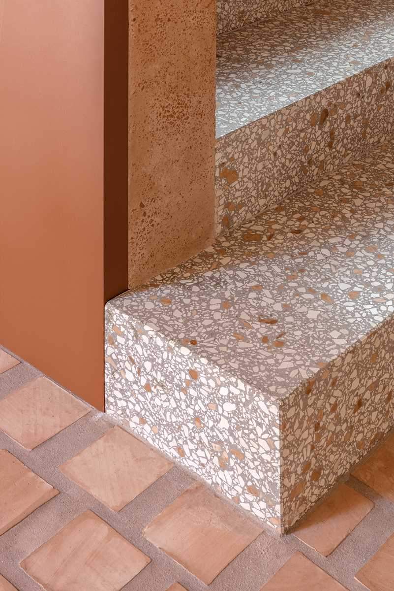 The lower level of this home features terrazzo stair treads, while the clay of the square cotto tiles has been used as aggregates mixed in the thick, lime-based plasterwork of the walls.