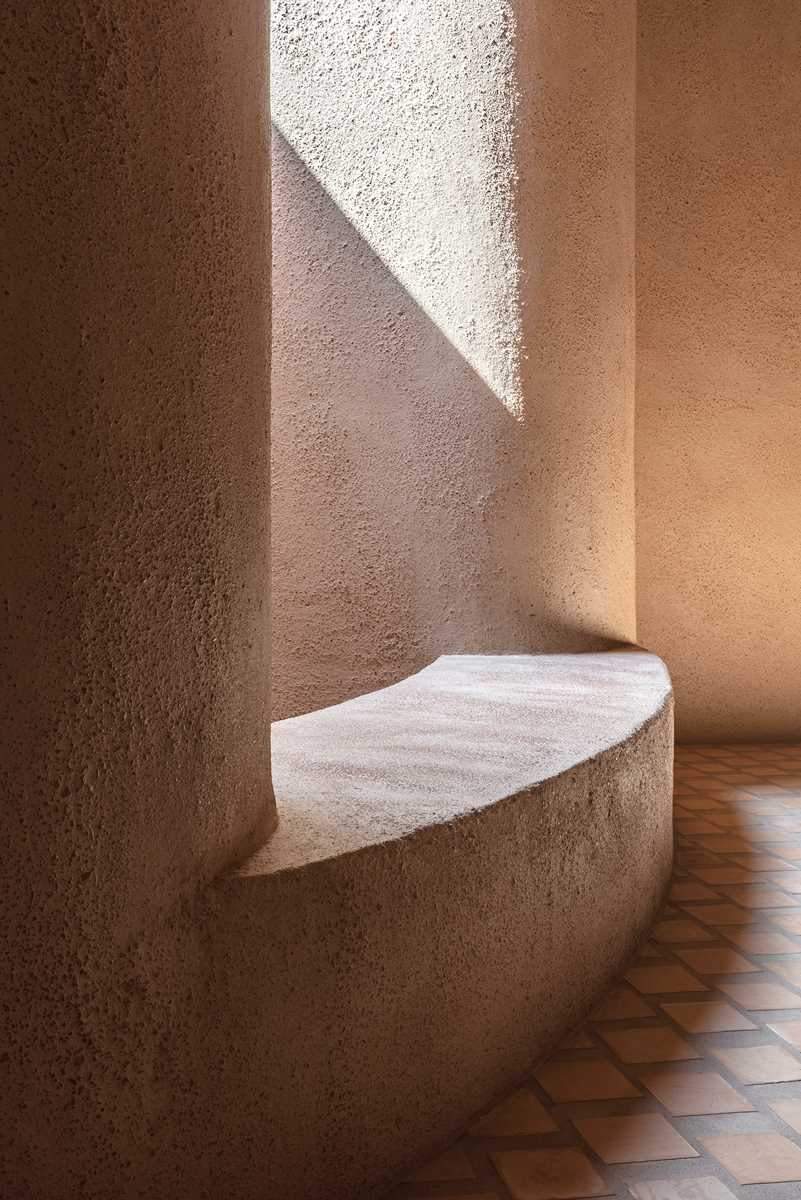 The lower level of this home features terrazzo stair treads, while the clay of the square cotto tiles has been used as aggregates mixed in the thick, lime-based plasterwork of the walls.