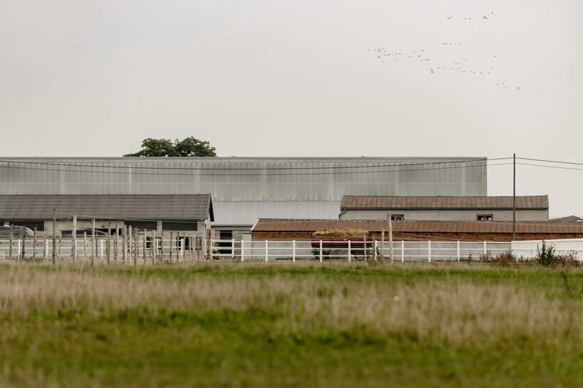 raw concrete, steel panels, and wood wrap wiercinski studio's equestrian center in poland