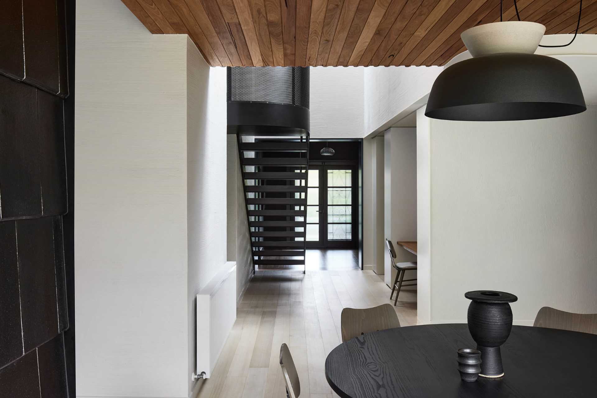 A modern open plan dining area with a round table.