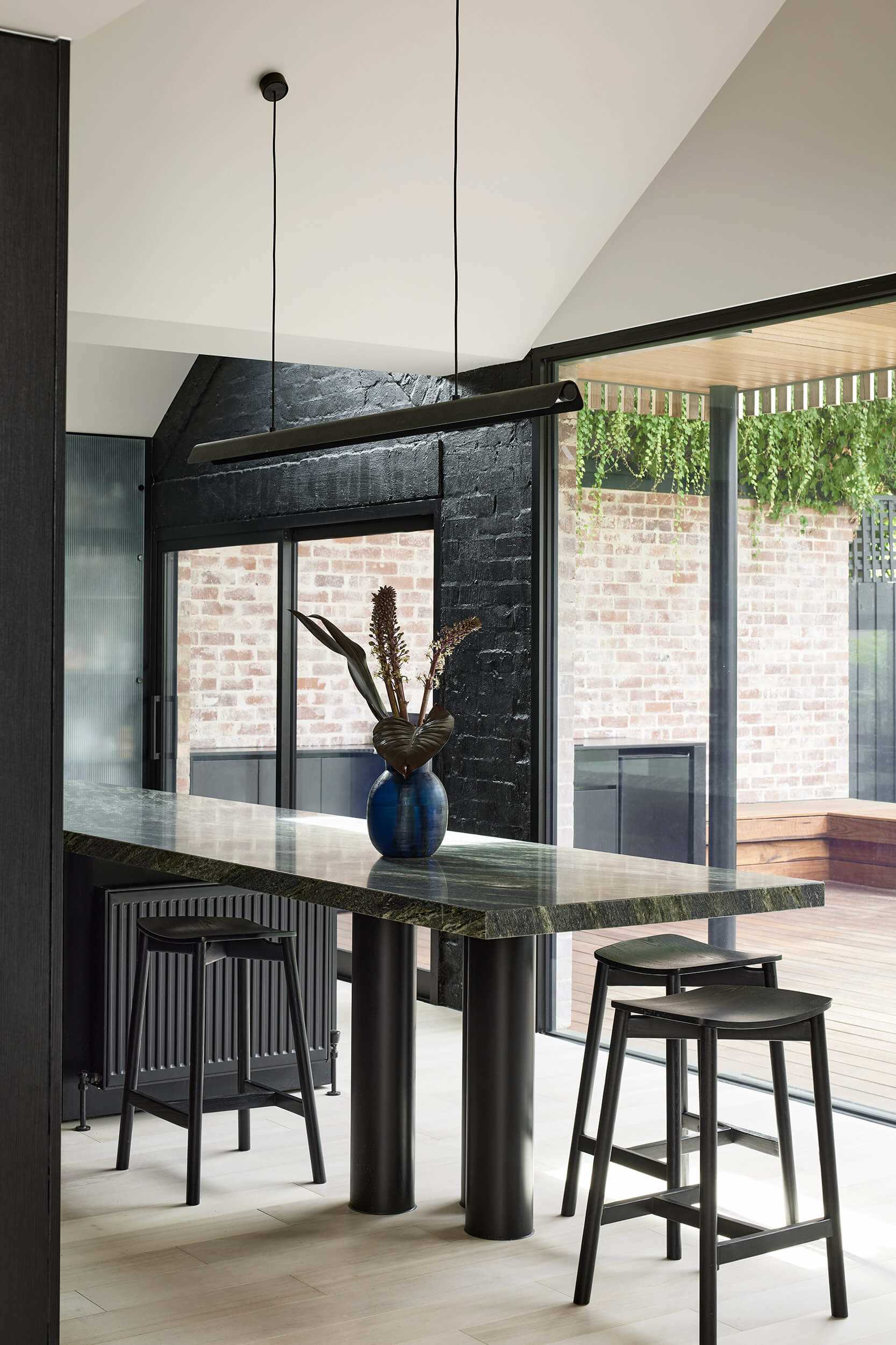 In the kitchen, dark cabinets, countertops, lighting, and painted brick wall, all assist in creating a bold appearance.