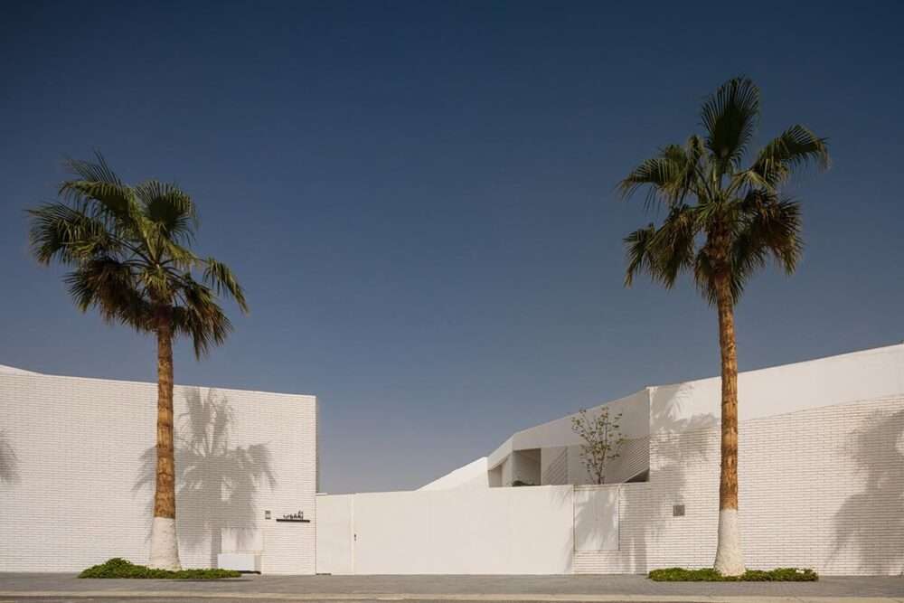 Covering a family home with a folded roof to create a tent-like structure in Kuwait