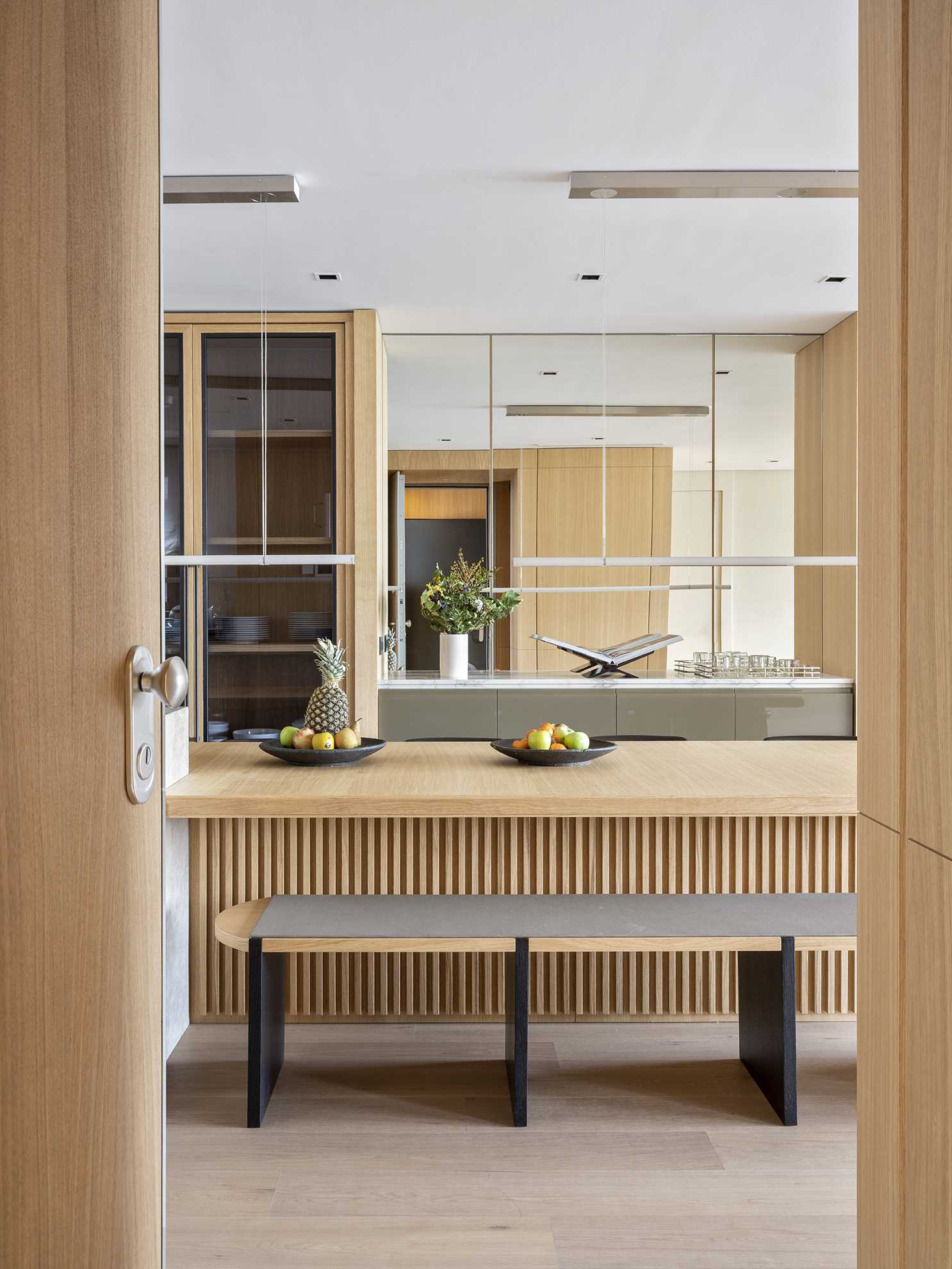 تم تصميم تصميم المطبخ المفتوح والواسع لدعوة المشاركة، حيث يلعب البار الرخامي وطاولة الطعام الخشبية الطويلة دور المضيف. تم أيضًا تضمين جدار معكوس في هذه المساحة.