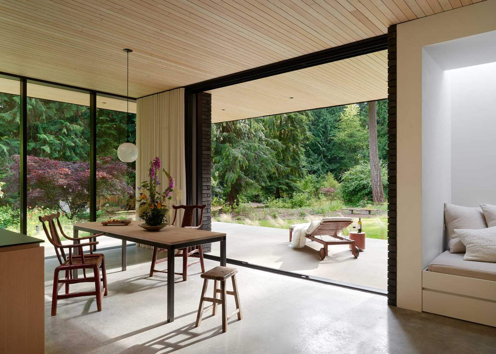 This modern home has a Douglas fir wood ceiling that's been lye-washed, while in the dining area, a table made from oak and steel has been designed by ?GO'C.