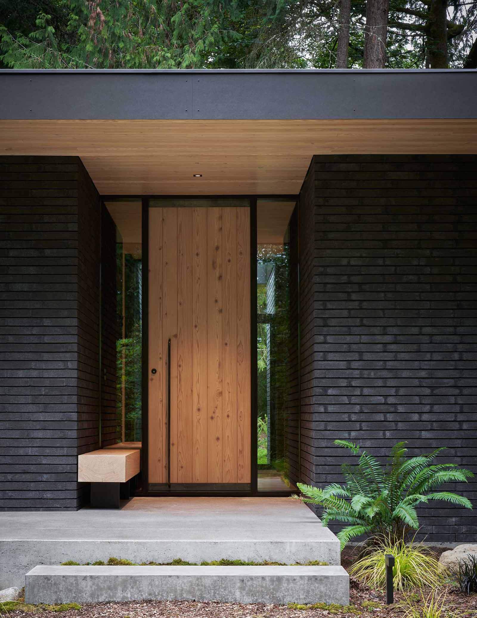 A modern home with a pivoting cedar front door.