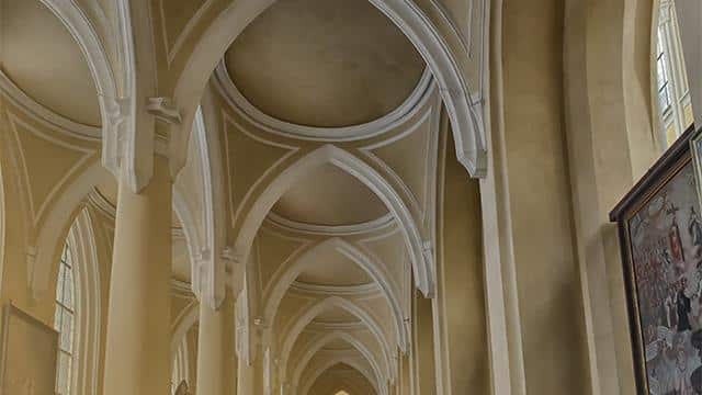 "Interior of a historic church showcasing groin vaulted ceilings."