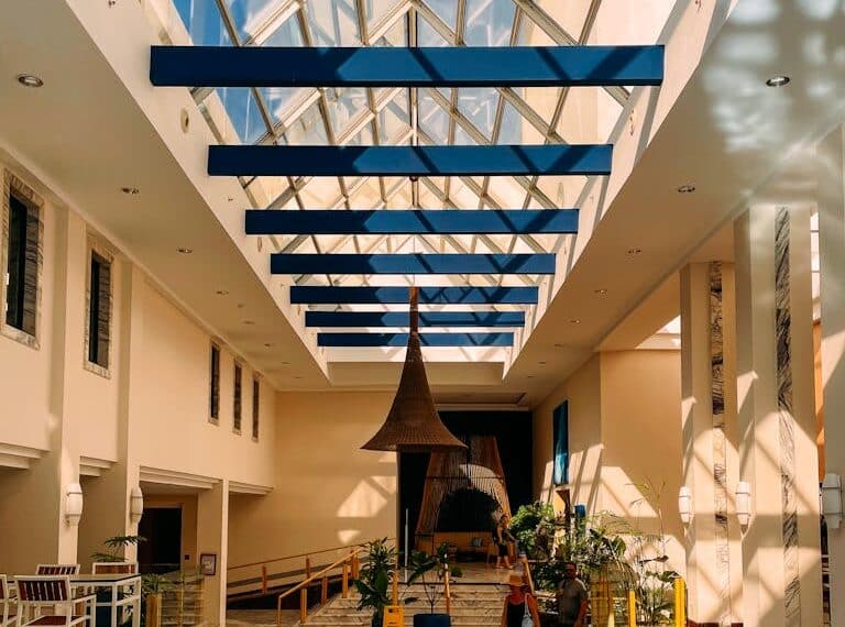 "لوبي فندق حديث بسقف مقبب ونوافذ سقفية لإضاءة طبيعية."