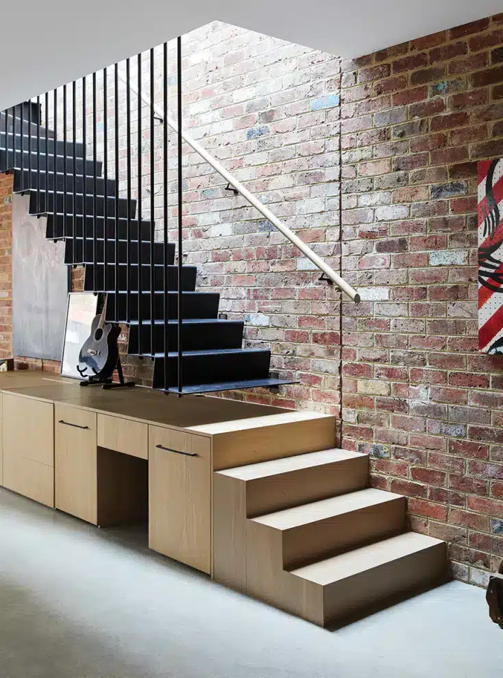 "Industrial-style metal balustrade adding a modern touch to an interior design with red brick walls."