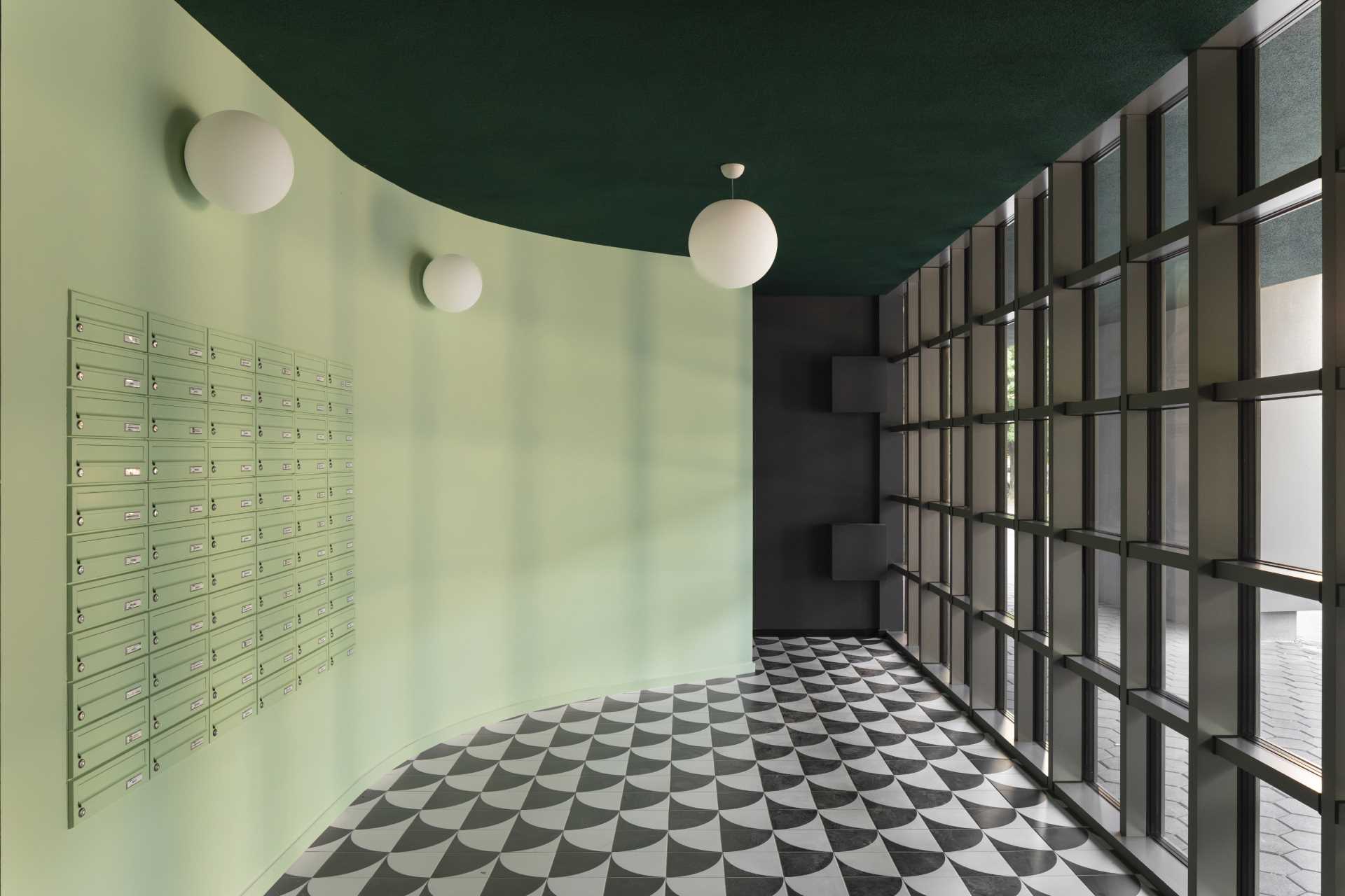 مبنى سكني حديث يتميز بتصميم داخلي باللون الأخضر النعناعي الذي يتناسب مع الواجهة المبلطة.