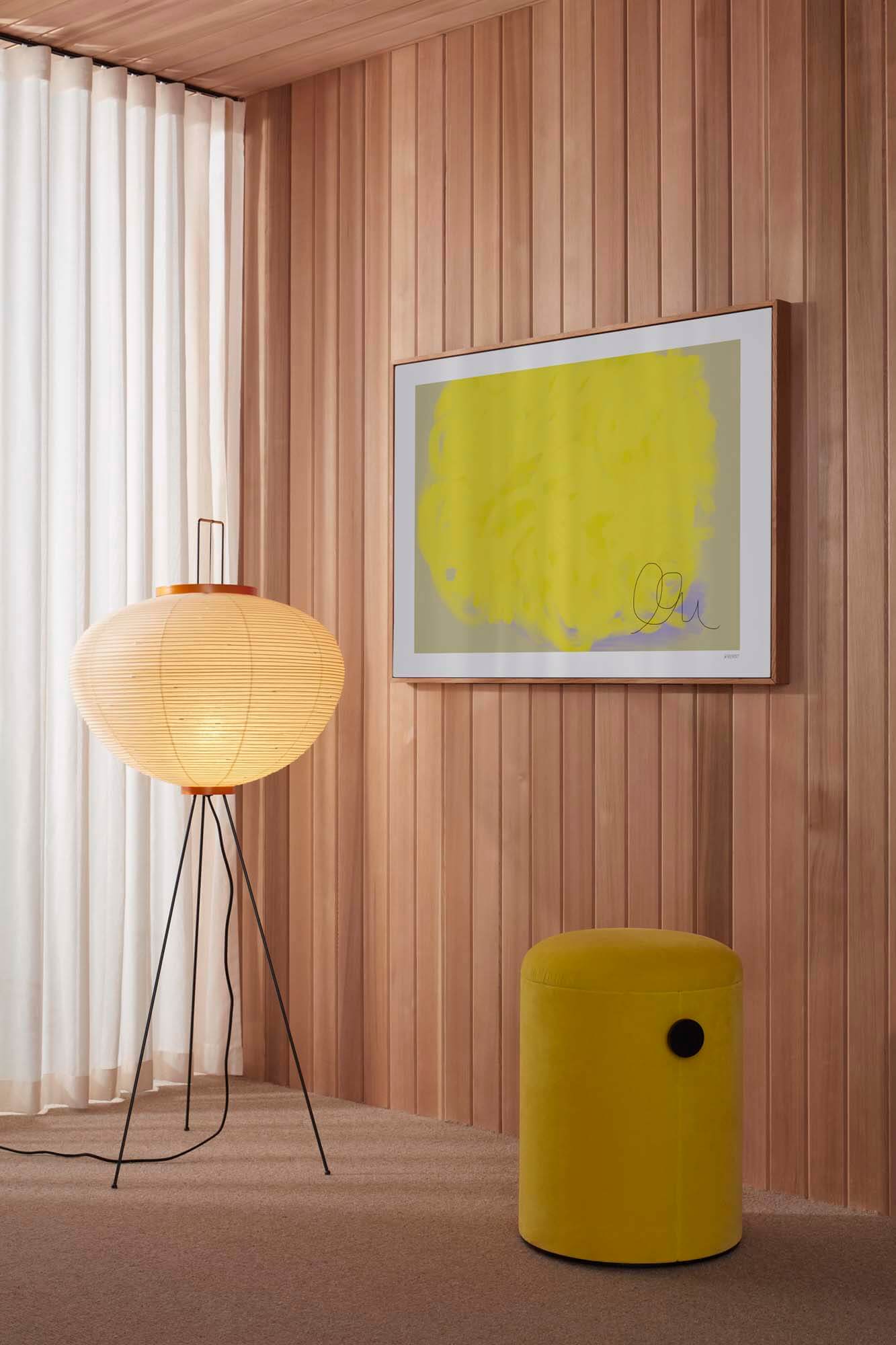 زاوية من الغرفة مغطاة بألواح خشبية دافئة توفر قاعدة للفن الصوتي المعاصر من تصميم Abstracta x Wall of Art.