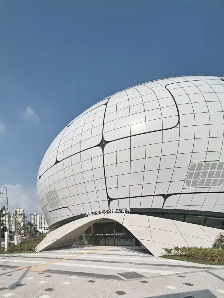 "Exterior view of the Seoul Robot Museum, featuring its distinctive spherical design covered in a metallic glass grid."