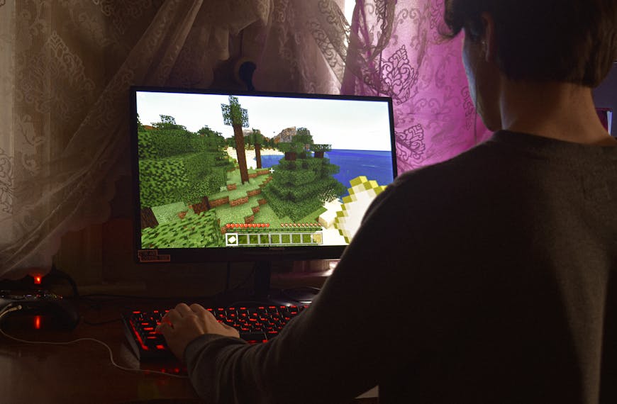 A young man intensely playing a PC video game indoors. Capturing the essence of technology and concentration.