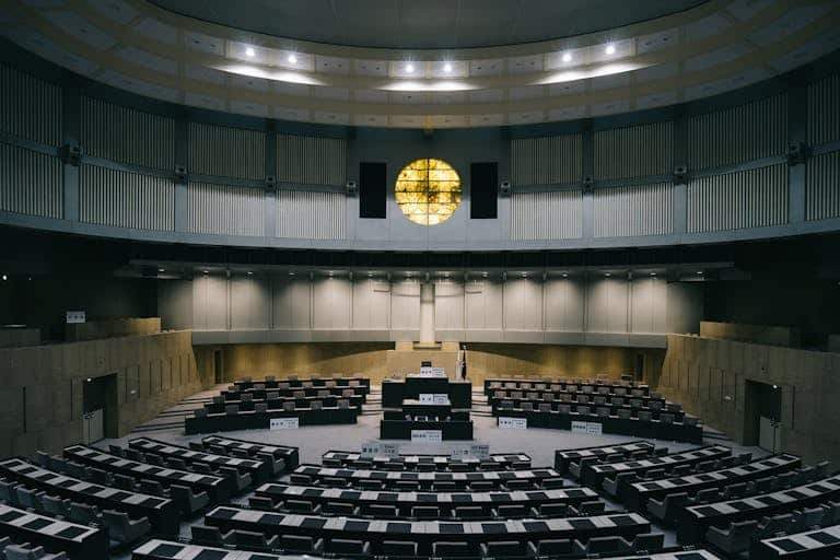 Interior of a modern legislative chamber with empty seats and a unique architectural design in Tokyo, Japan.