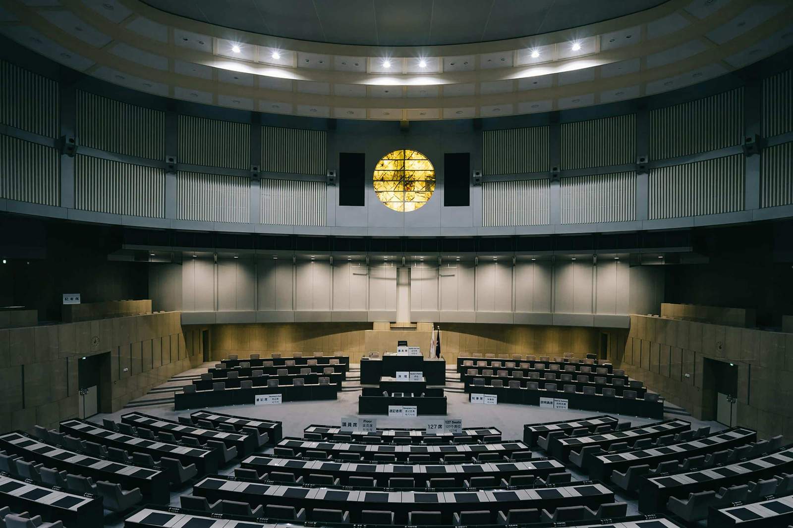 Interior of a modern legislative chamber with empty seats and a unique architectural design in Tokyo, Japan.