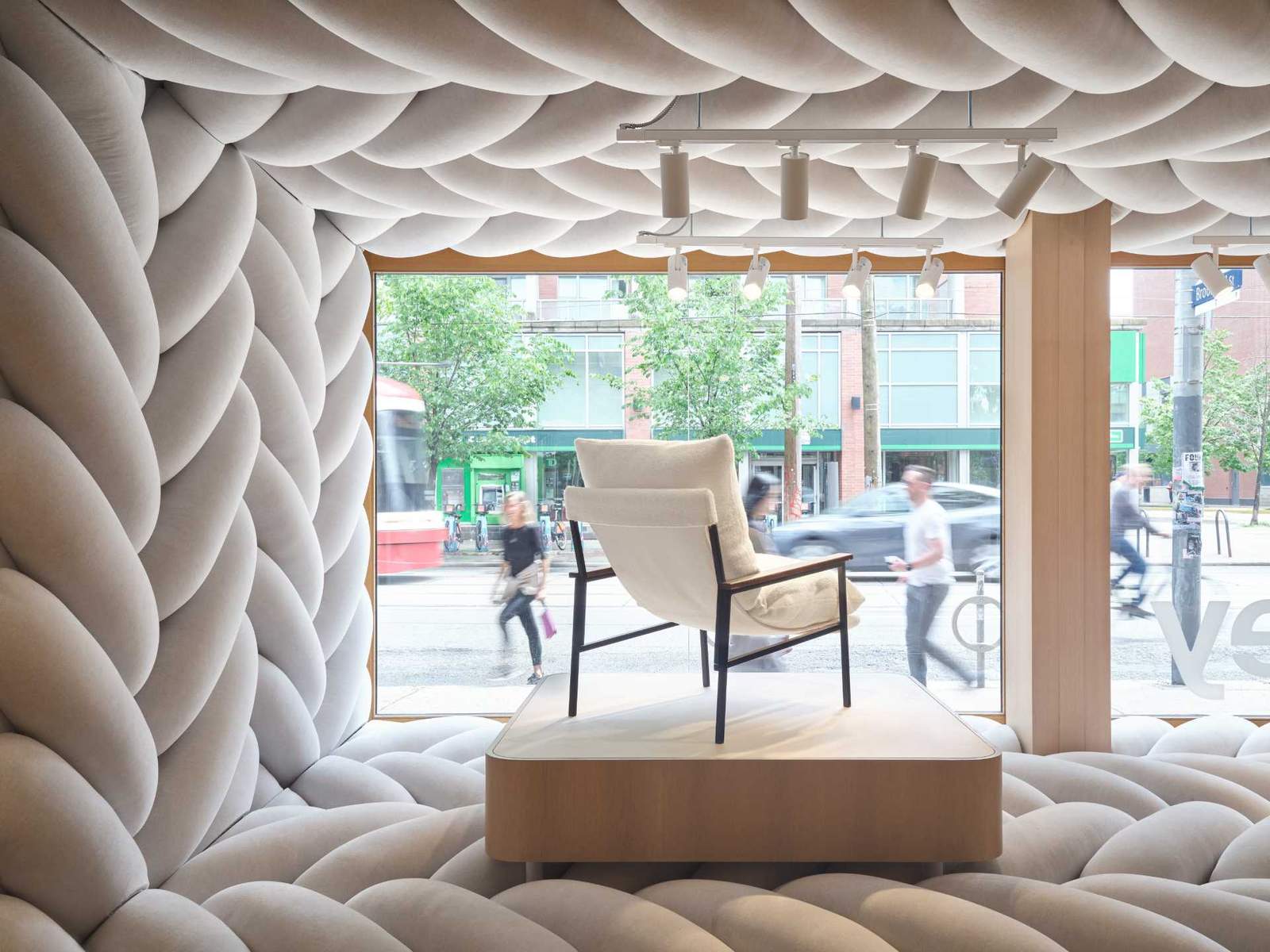 The design of this retail window showcase displays a giant fabric weave to draw pedestrians inside the space.