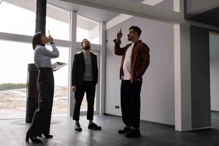 Three real estate agents discussing design in a modern apartment space.