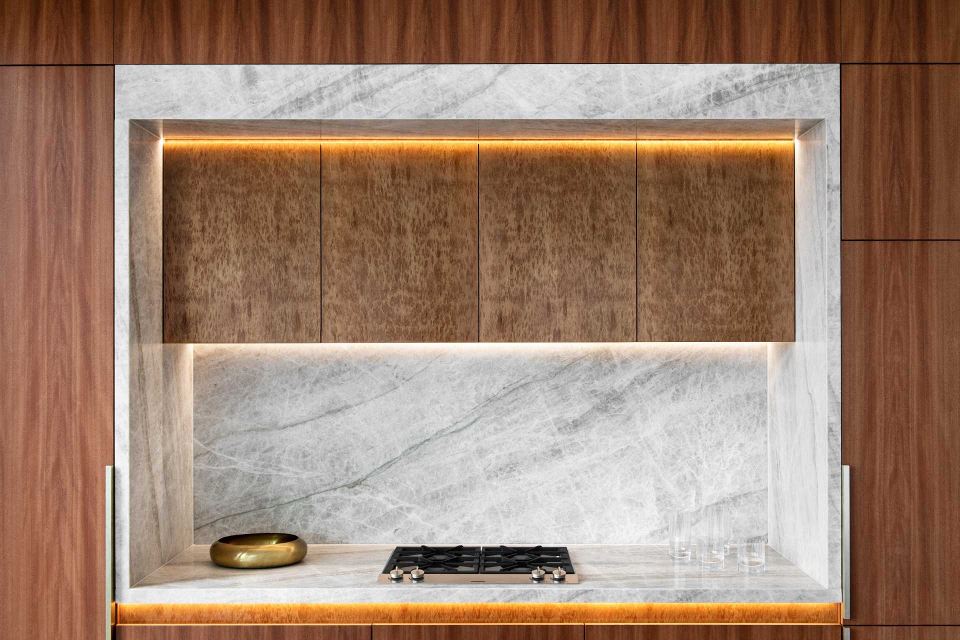 مطبخ معاصر به جزيرة كبيرة وخزائن خشبية وإضاءة LED.