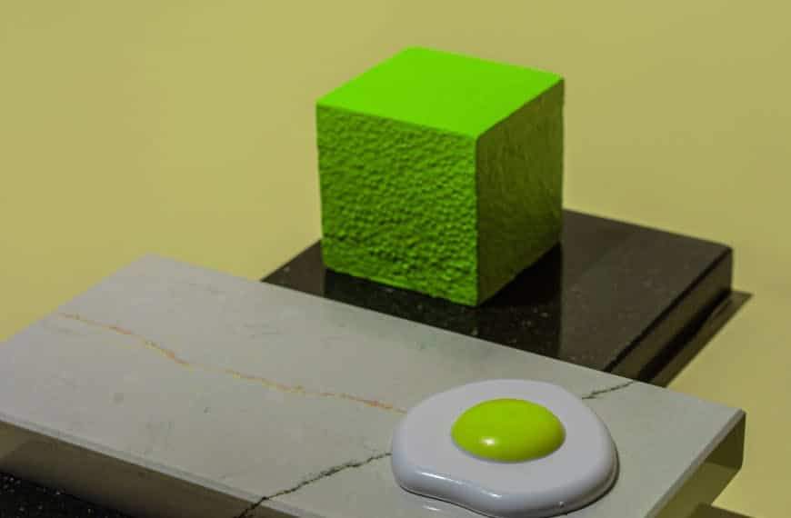 Artistic still life of a neon green cube and egg shape on geometric tiles. Modern and conceptual.