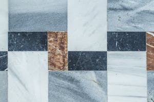 Close-up of a geometric marble tile pattern with natural texture colors.