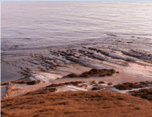 "منظر طبيعي لشاطئ بونتا بيانكا مع البحر الهادئ، يبرز فيه التصميم المستدام الذي تسعى إليه مسابقة بونتا بيانكا
