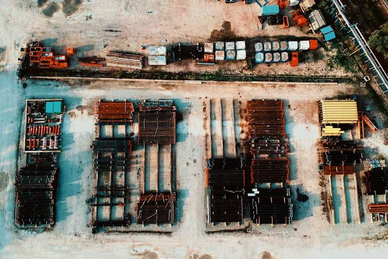 A high angle shot showcasing an industrial yard featuring stacks of steel and metal materials.