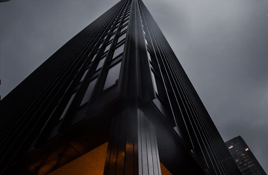 A low angle view of skyscrapers reaching into a moody night sky, showcasing modern architecture.