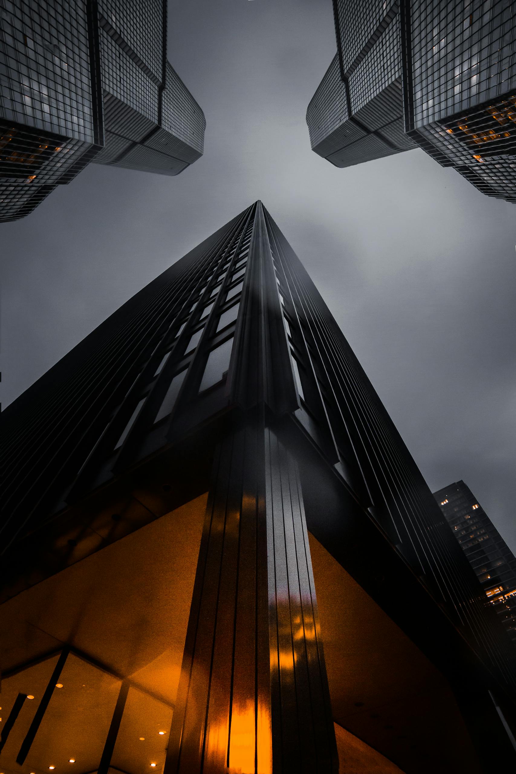 A low angle view of skyscrapers reaching into a moody night sky, showcasing modern architecture.