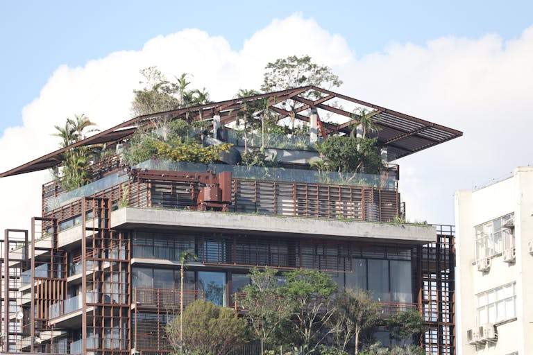 Contemporary building featuring lush rooftop garden and wood-metal architecture.