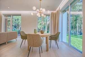 Elegant dining room featuring modern furniture and large windows for natural light.