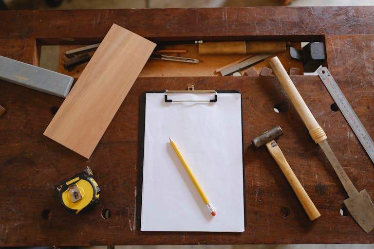 Flatlay of carpentry tools on a wooden workbench, showcasing craftsmanship essentials.