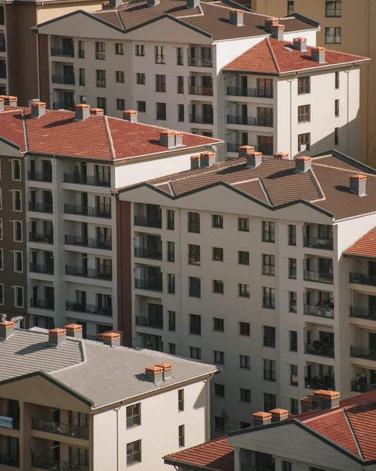 High angle view of modern urban apartment buildings with red roofs and balconies.