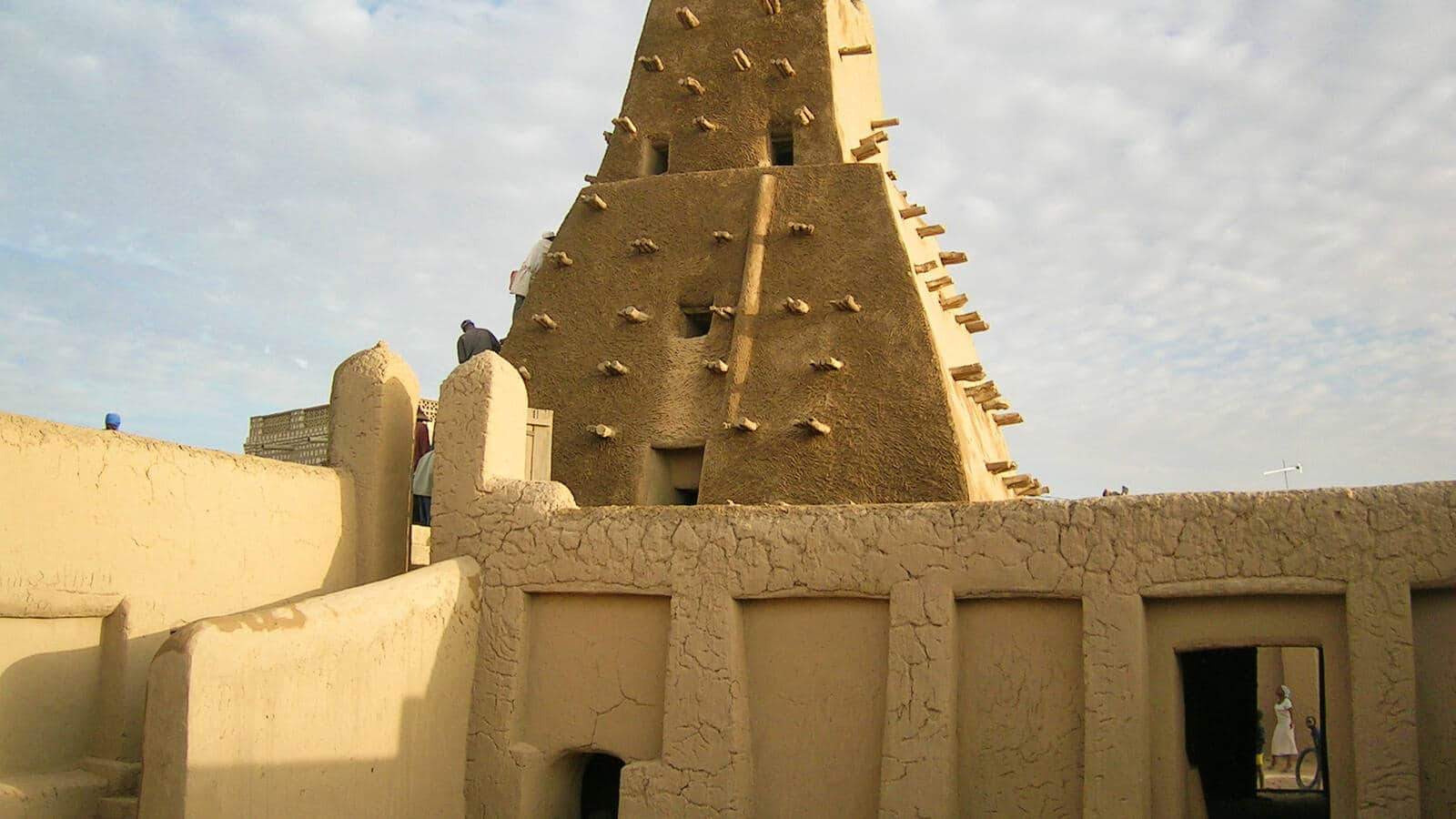 مبنى مكون من طوب طيني، يُظهر العمارة الترابية التقليدية مع النصوص الطبيعية والمواد المستدامة.