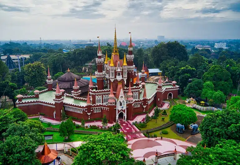 Aerial view of a vibrant castle surrounded by lush greenery in Indonesia.
