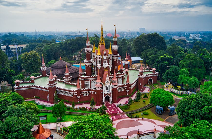 Aerial view of a vibrant castle surrounded by lush greenery in Indonesia.