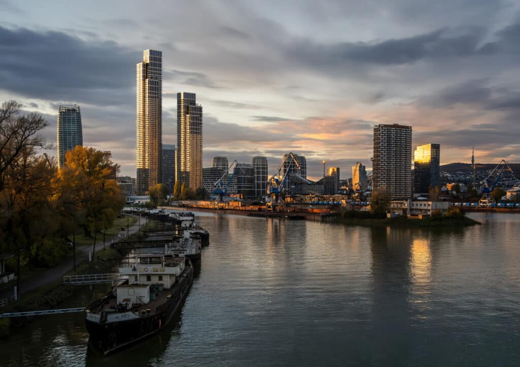 scenic view of the Istropolis project in Bratislava, with a river flowing alongside modern urban spaces and green areas.