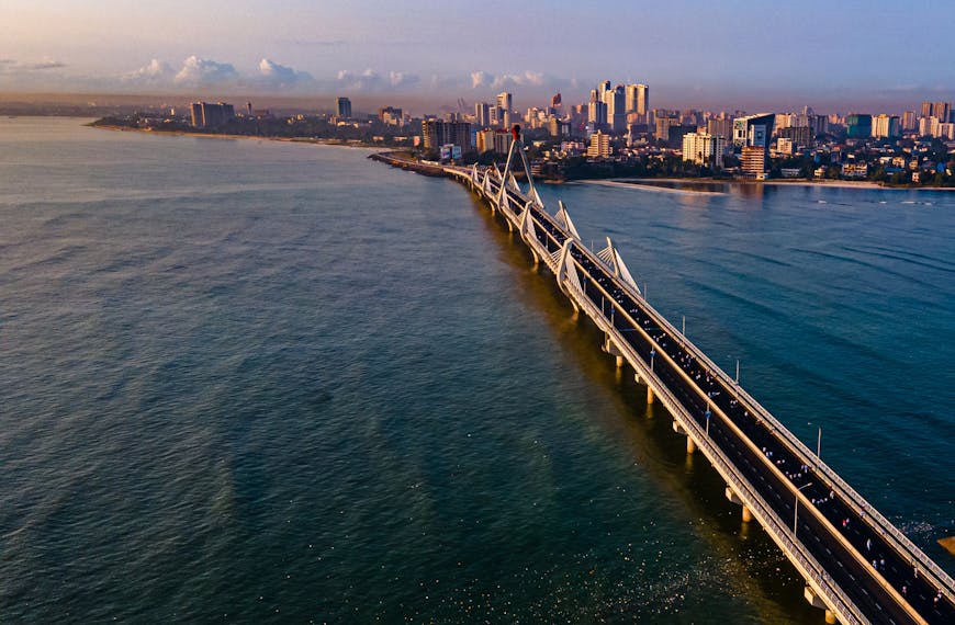 Stunning aerial view of Tanzanite Bridge and skyline in Dar es Salaam at sunset.
