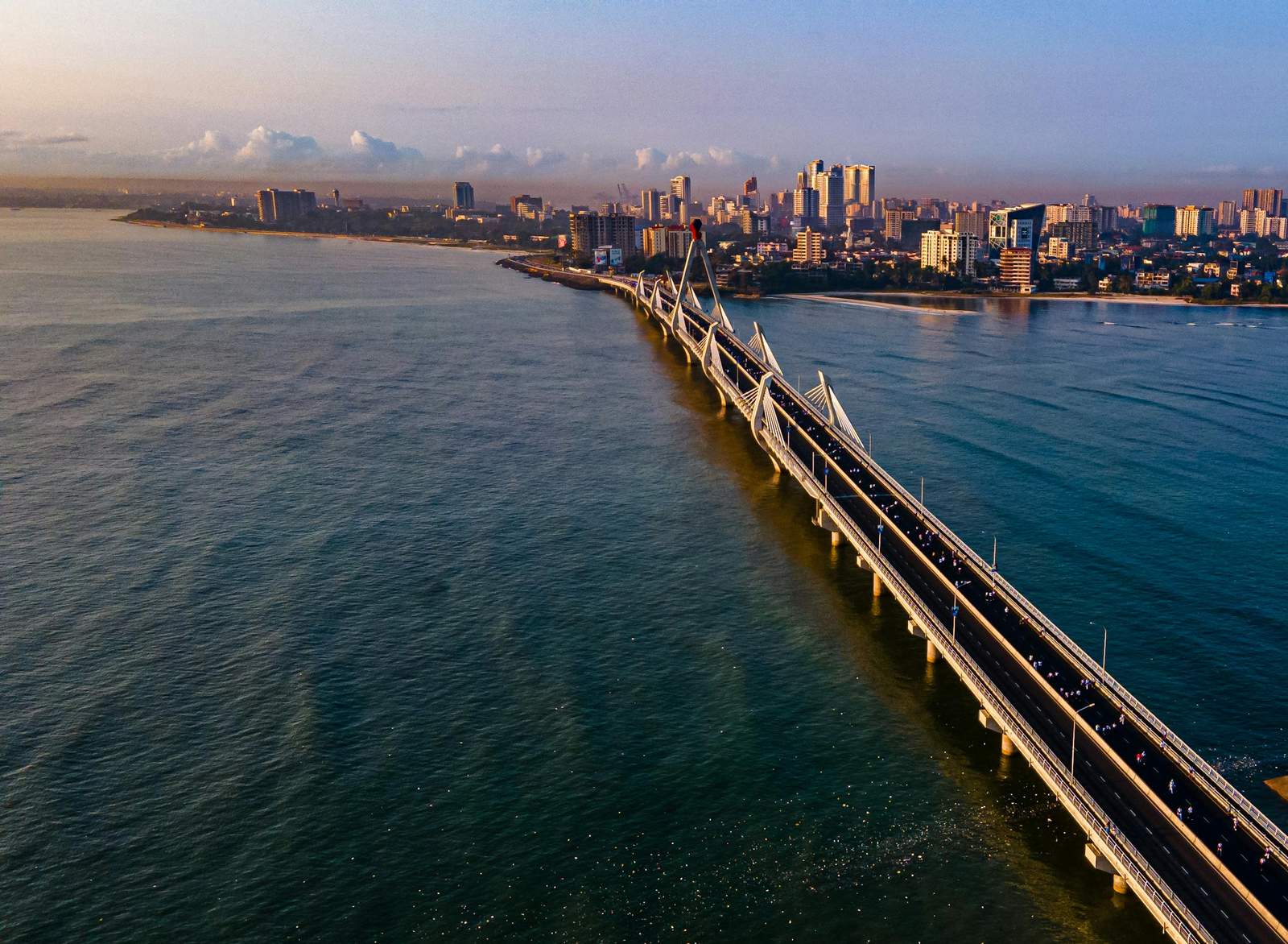 Stunning aerial view of Tanzanite Bridge and skyline in Dar es Salaam at sunset.