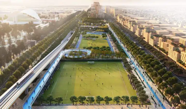 A modern sports stadium captured from an aerial view, showcasing its geometric design and surrounding green spaces.