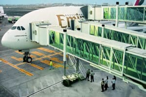 Passenger boarding bridge connected to an Emirates A380 aircraft at Dubai International Airport.