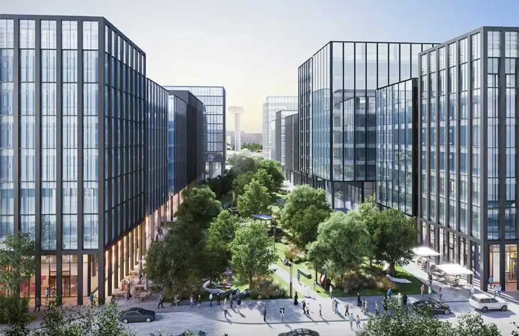 A modern business complex featuring glass architecture and green spaces.