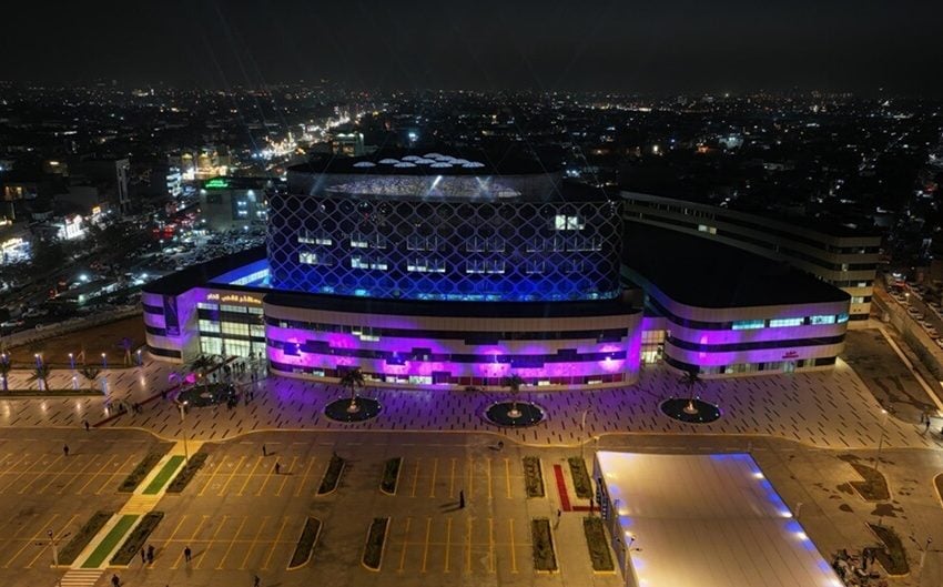 "Modern hospital illuminated with blue and purple lights, showcasing an advanced architectural design as part of the hospital construction projects in Iraq."