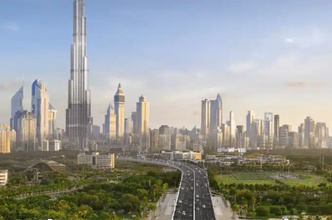 A view of Dubai featuring Burj Khalifa with a highway surrounded by greenery