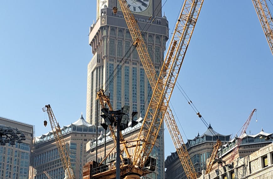 Abraj Al Bait Towers with cranes, showcasing Islamic architecture and urban development.