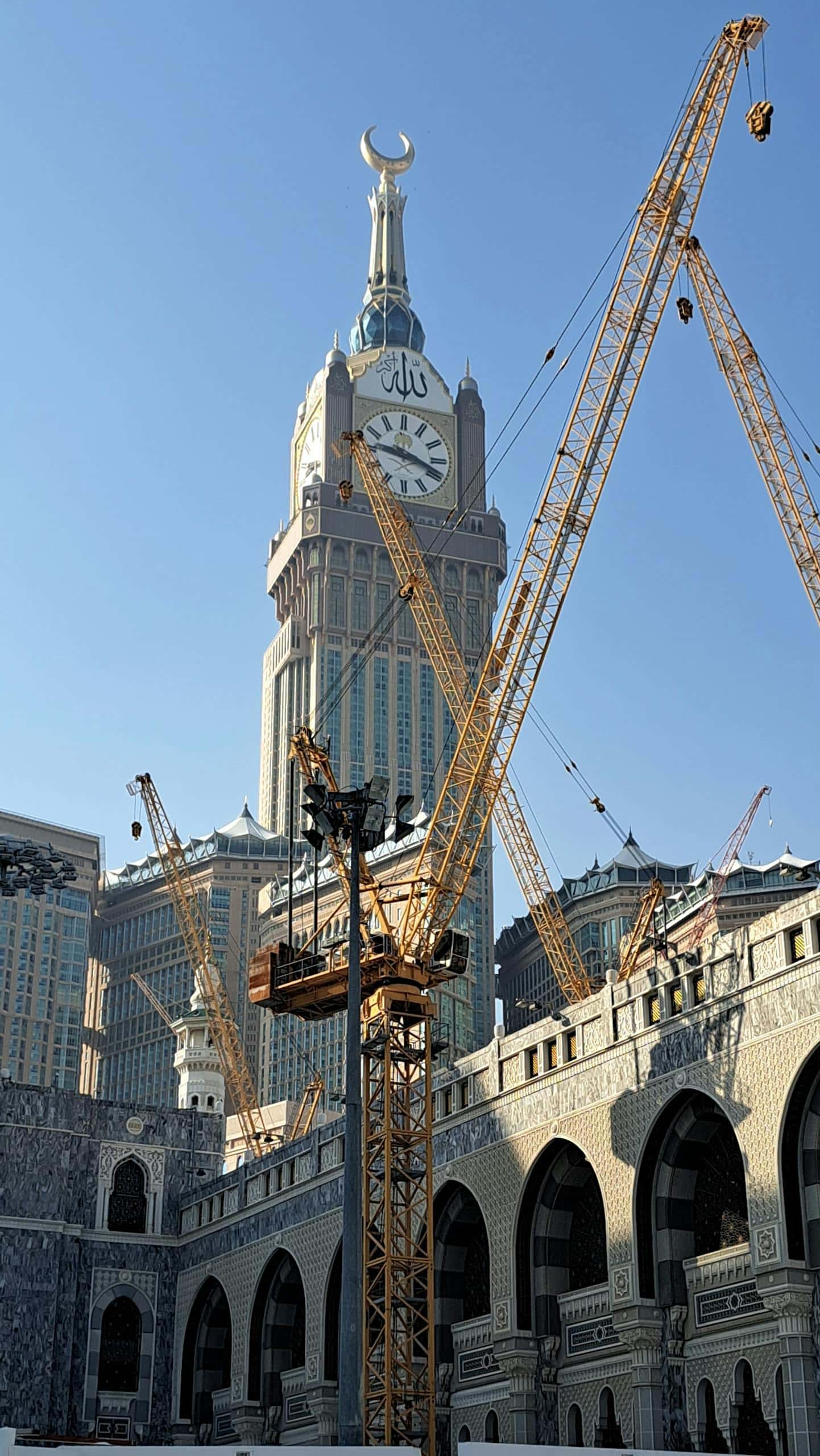 Abraj Al Bait Towers with cranes, showcasing Islamic architecture and urban development.
