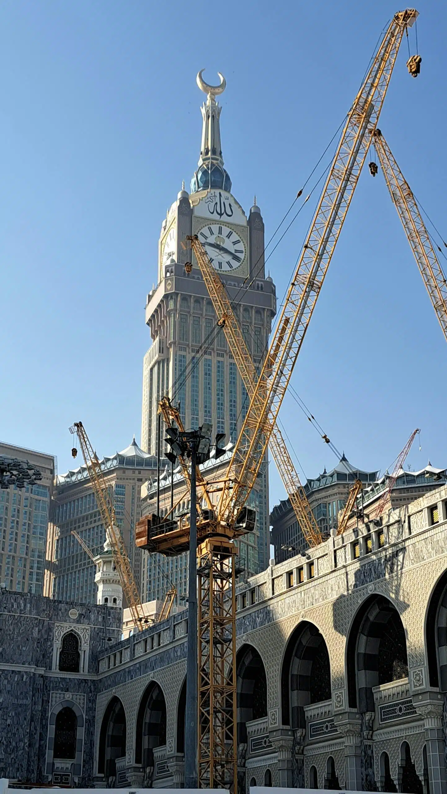 Abraj Al Bait Towers with cranes, showcasing Islamic architecture and urban development.