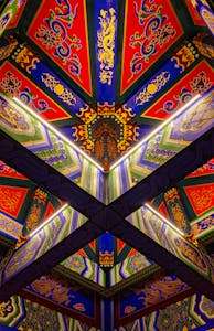 Intricately designed Chinese temple ceiling with vibrant colors and patterns.