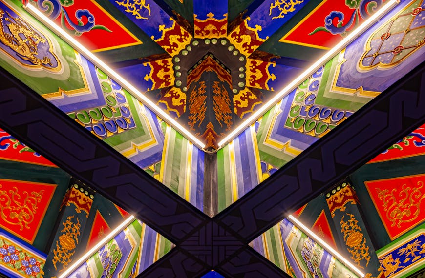 Intricately designed Chinese temple ceiling with vibrant colors and patterns.
