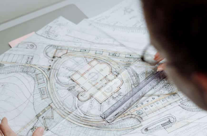 Professional architect analyzing detailed blueprints at a workplace.