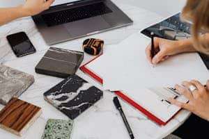 Workspace showing architectural design process with material samples and drawing.